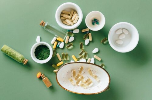 Een kleurrijke verzameling van vitamines en supplementen op een houten tafel, met innovatieve technologie in de achtergrond.