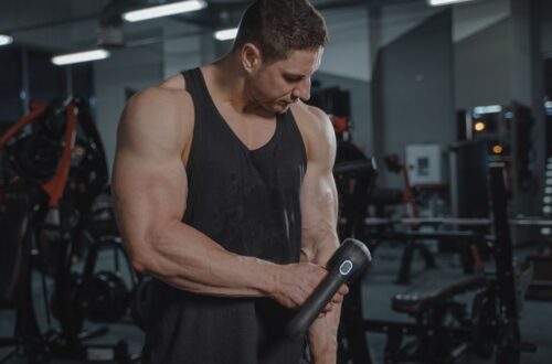 Een massagegun in gebruik voor spierpijn herstel na een intensieve training, geschikt voor sporters en fysiotherapeuten.